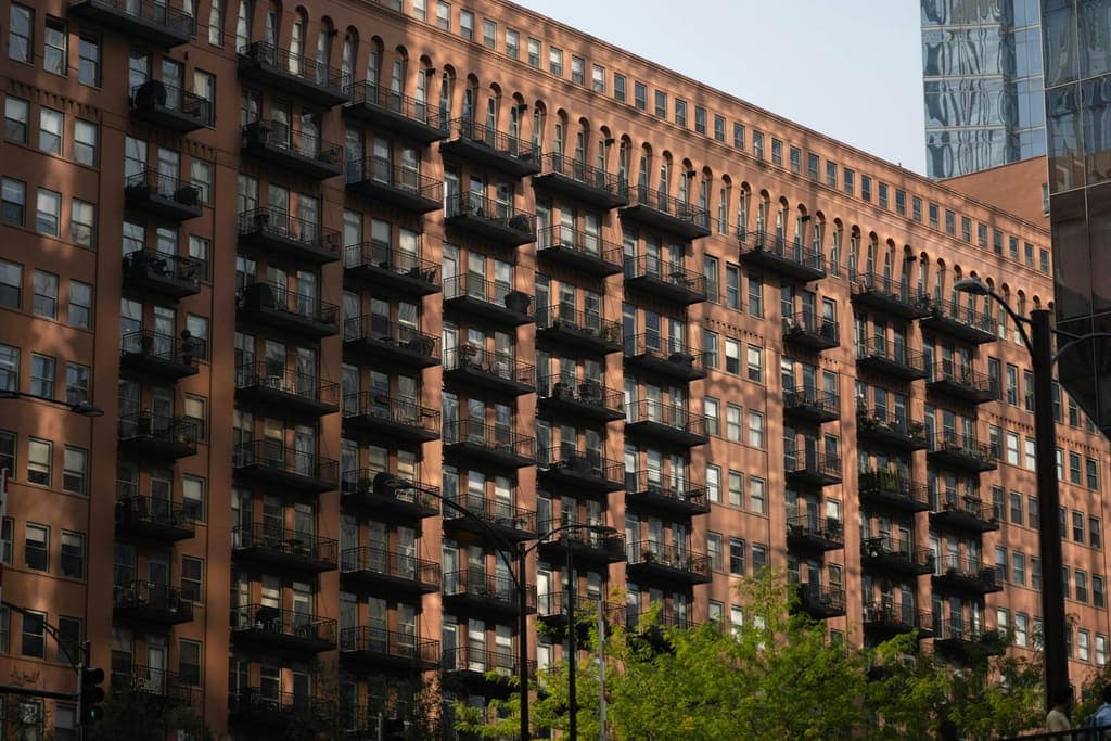 Multi-story Chicago apartment building with rows of balconies in warm evening light